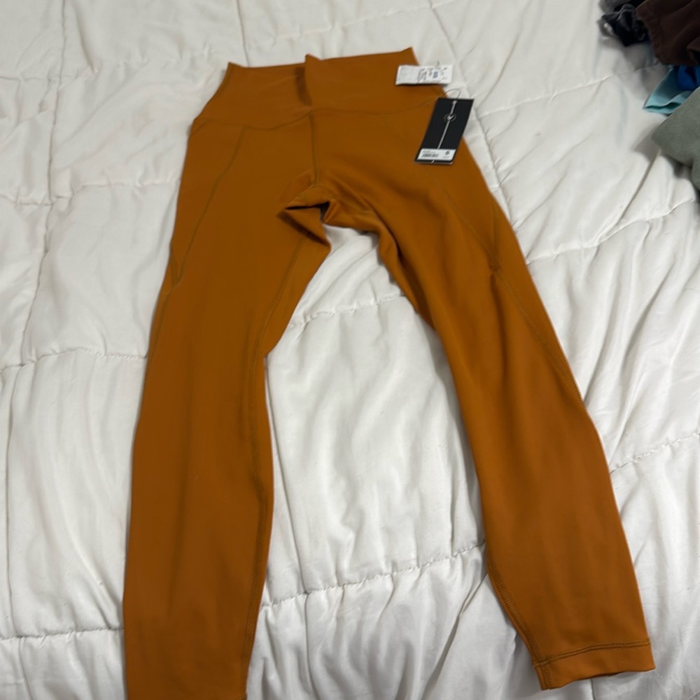 Orange brownish leggings. NEVER BEEN WORN AND STILL HAS TAG.